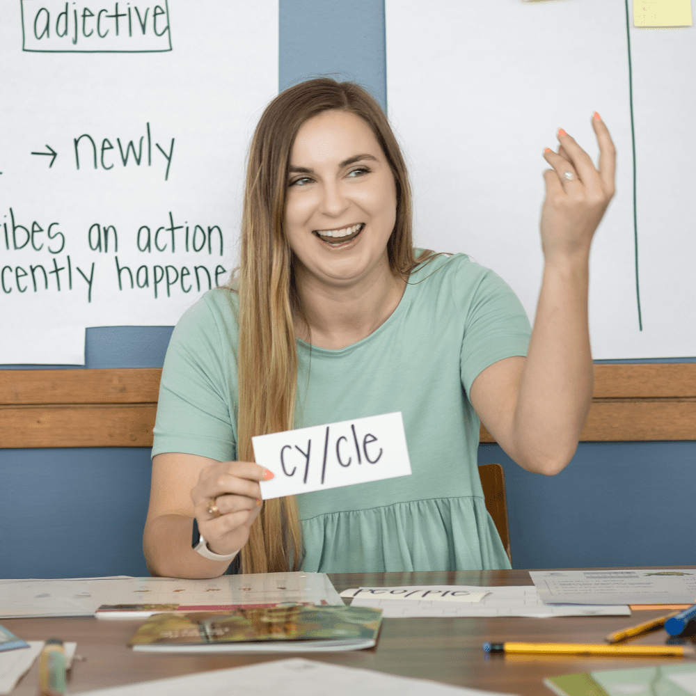 Smiling woman holding a text card in her hand.